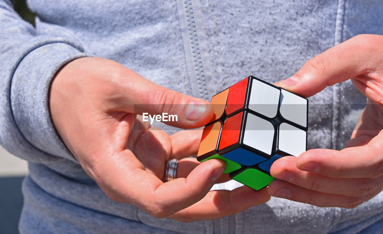 Midsection of man holding puzzle cube