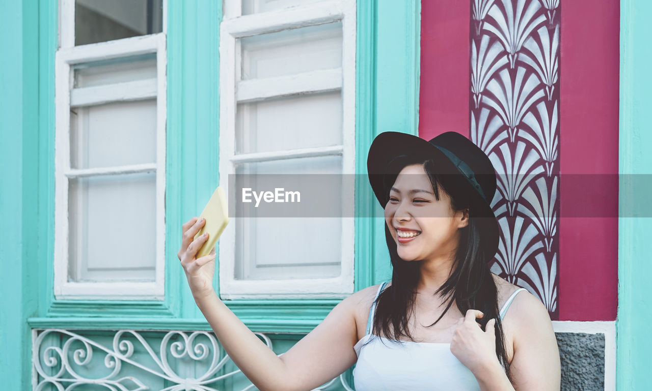 Smiling young woman taking selfie outdoors