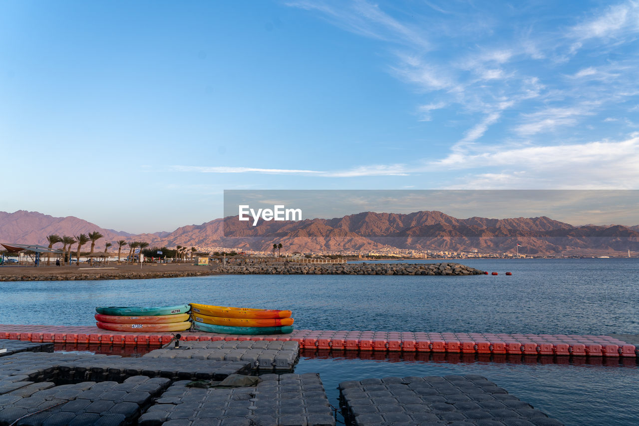 sea, water, sky, mountain, shore, horizon, coast, ocean, nature, bay, reflection, transportation, dusk, scenics - nature, nautical vessel, body of water, blue, no people, mountain range, morning, vacation, architecture, travel destinations, land, vehicle, outdoors, travel, landscape, beauty in nature, cloud, day, harbor, environment, pier, mode of transportation, tranquility, boat, ship, beach