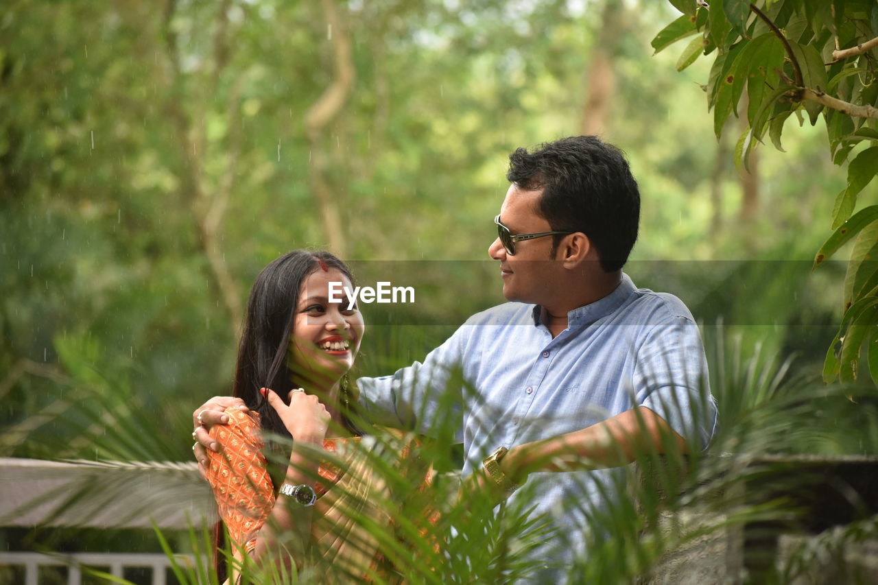 Smiling young couple against plants