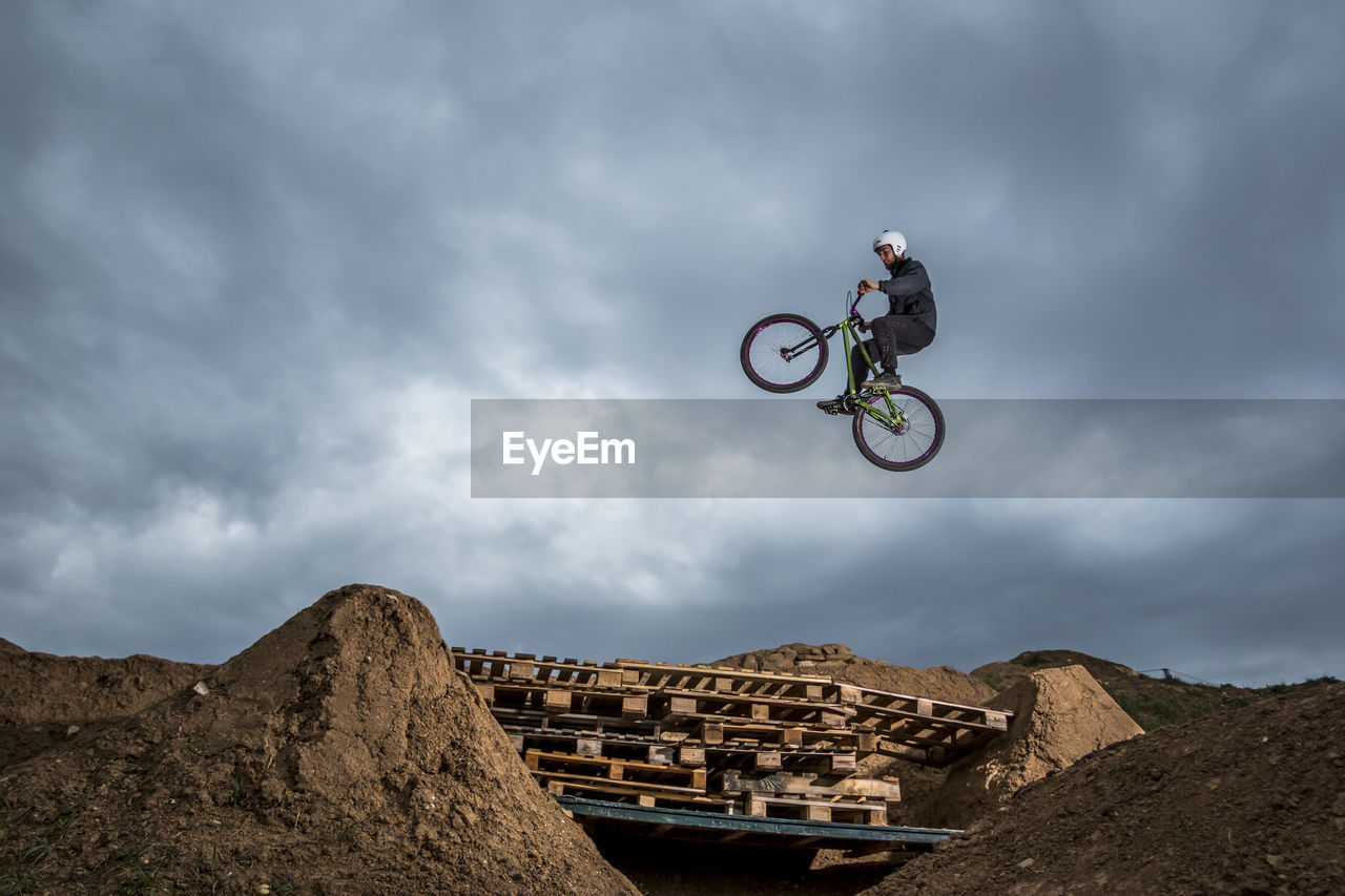 Low angle view of man jumping while doing bmx cycling