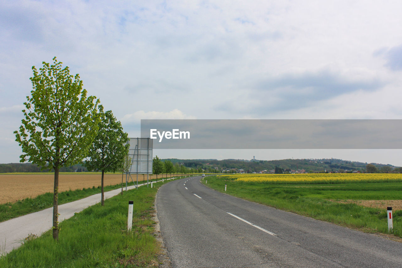 Road by landscape against sky