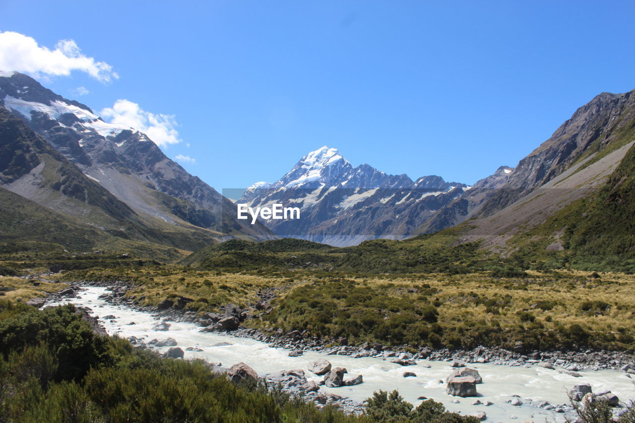 scenic view of snowcapped mountains against blue sky