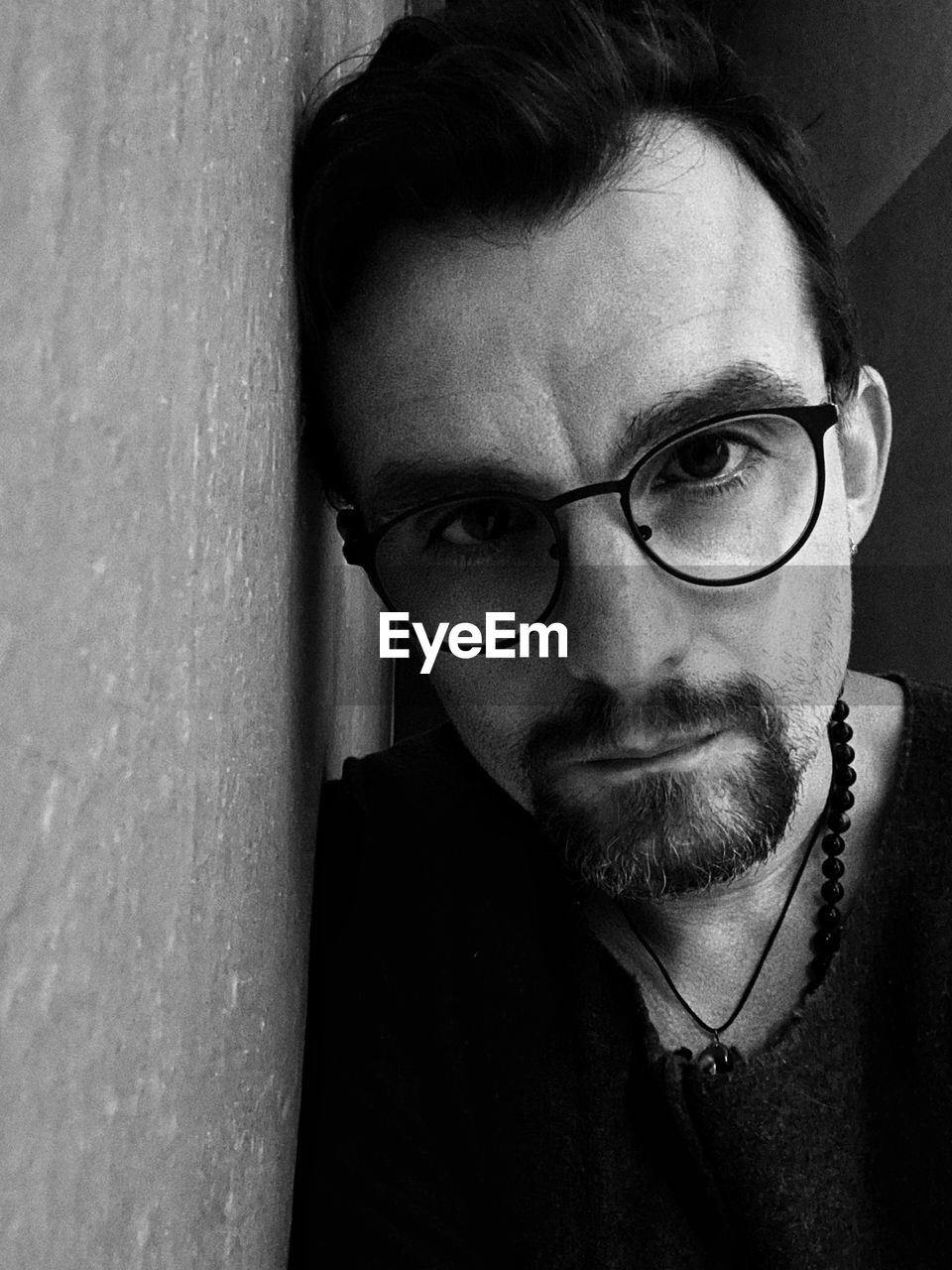 black, eyeglasses, glasses, portrait, one person, white, vision care, black and white, headshot, adult, looking at camera, monochrome, monochrome photography, men, wall - building feature, eyewear, beard, front view, lifestyles, indoors, facial hair, human face, close-up, human hair, person, young adult, portrait photography, serious, leisure activity, contemplation, looking, casual clothing, mature adult