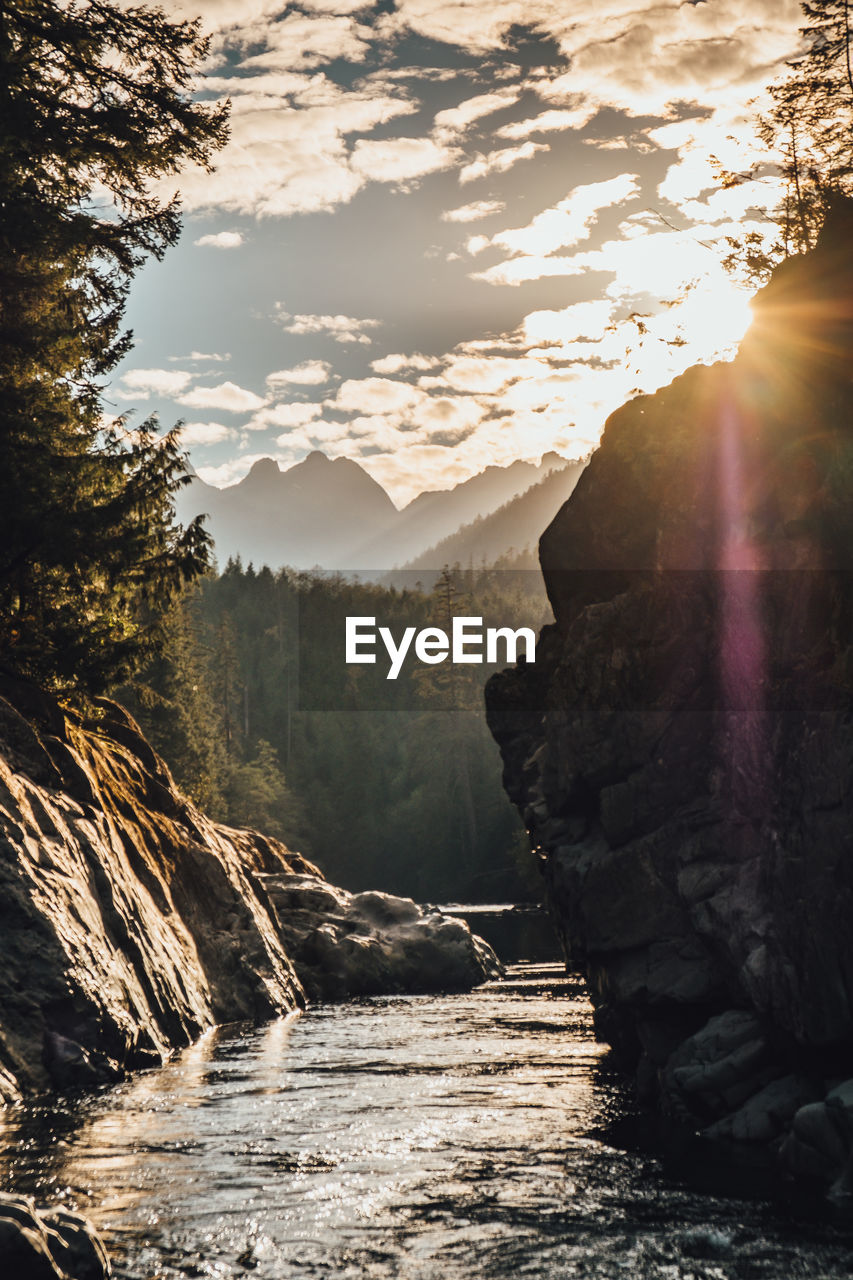 Scenic view of river amidst mountains against sky