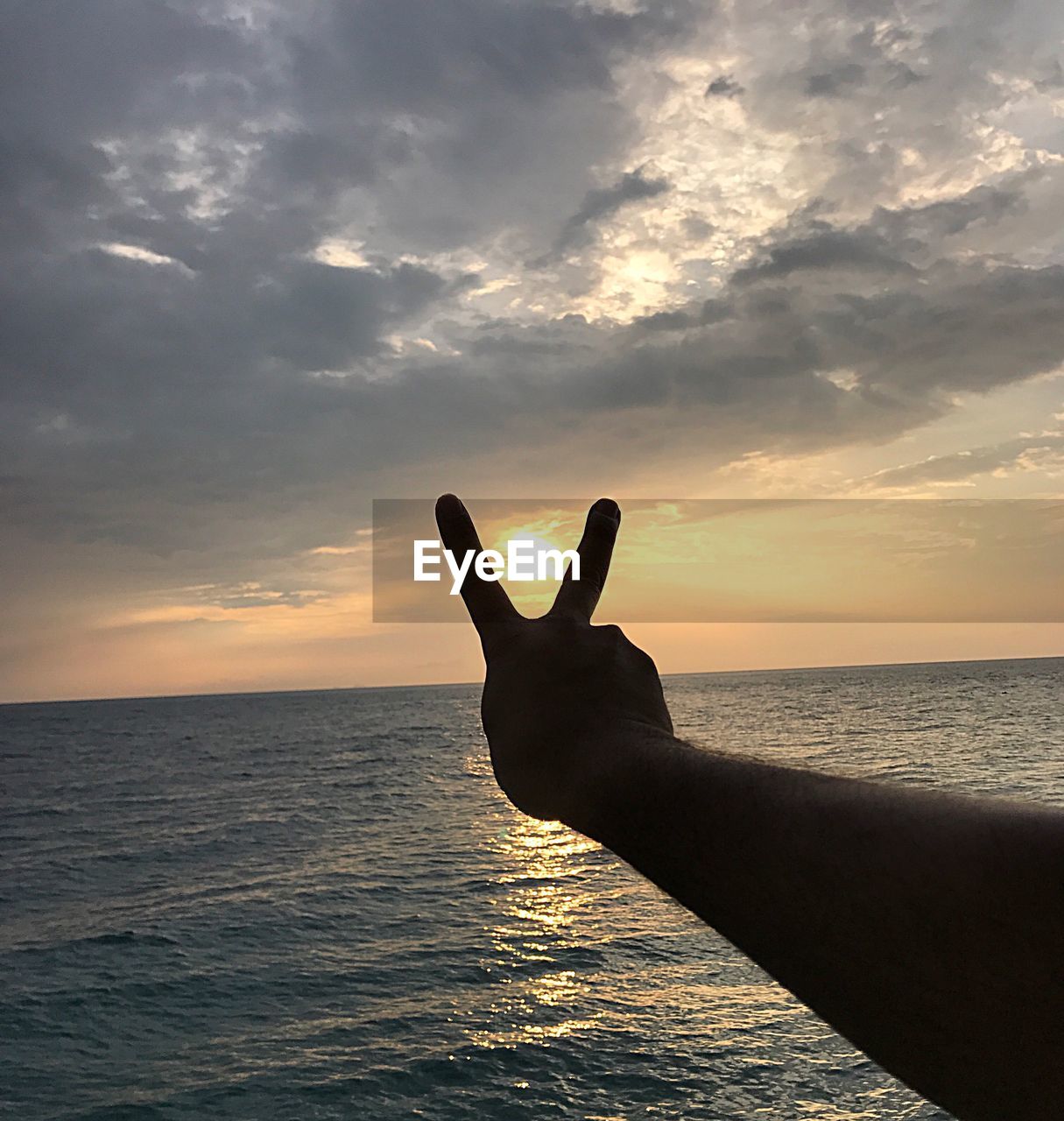 PERSON ON SEA DURING SUNSET AGAINST SKY