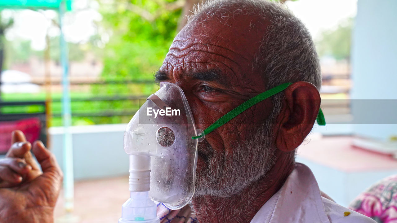 Close-up of man wearing nebulizer