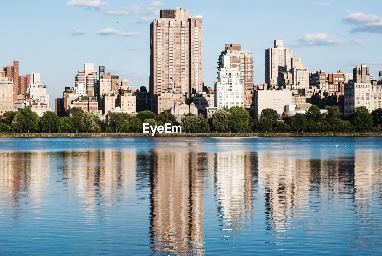 Reflection of buildings in river against sky