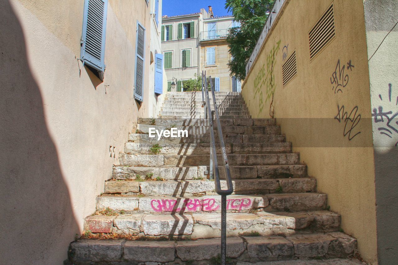 Low angle view of staircase amidst old buildings