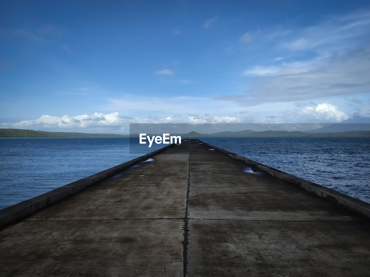 Pier over sea against blue sky