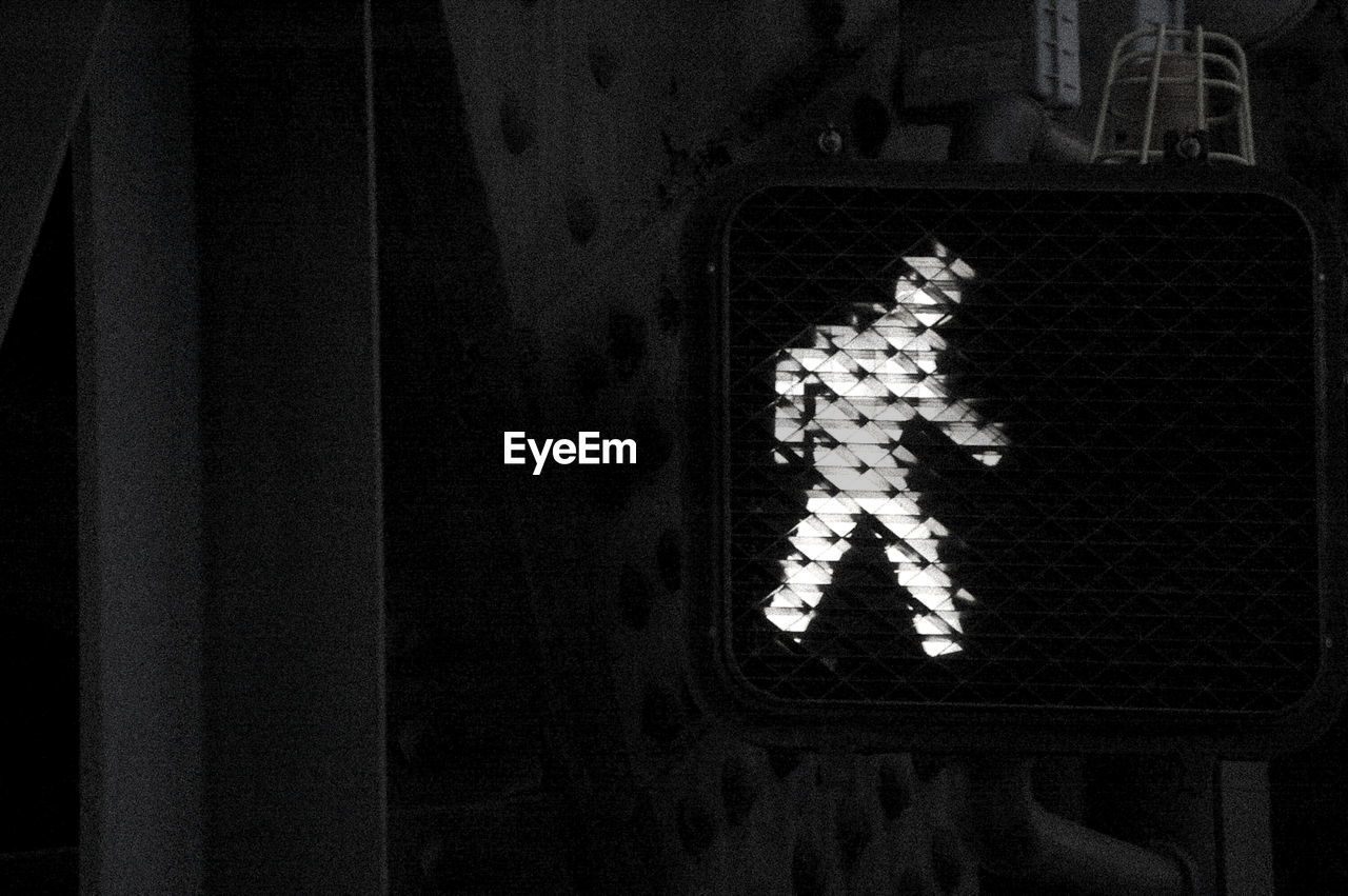 Close-up of illuminated pedestrian sign