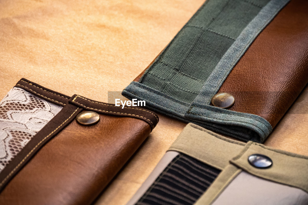 HIGH ANGLE VIEW OF LEATHER ON TABLE AGAINST THE BACKGROUND