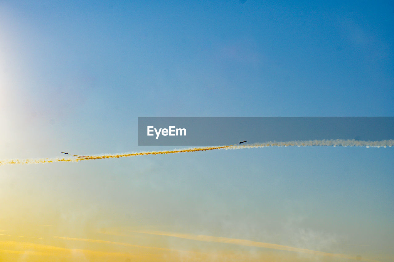 Low angle view of vapor trail against blue sky