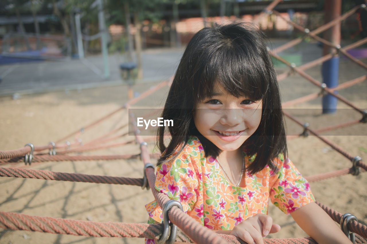 Portrait of smiling girl on jungle gym in park