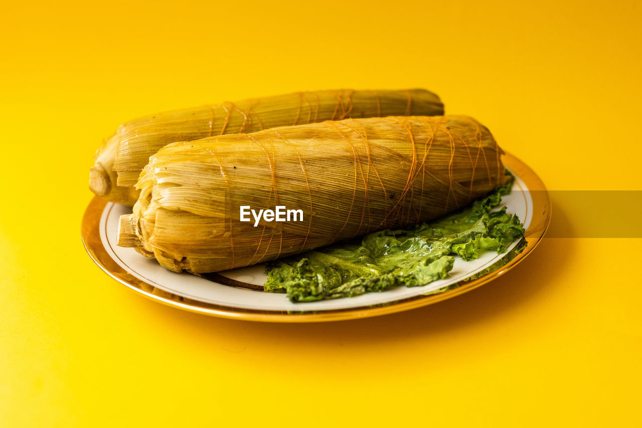 High angle view of food in plate against yellow background