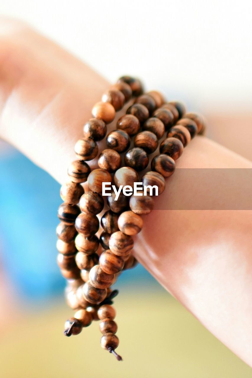 Cropped hand wearing beads bracelet