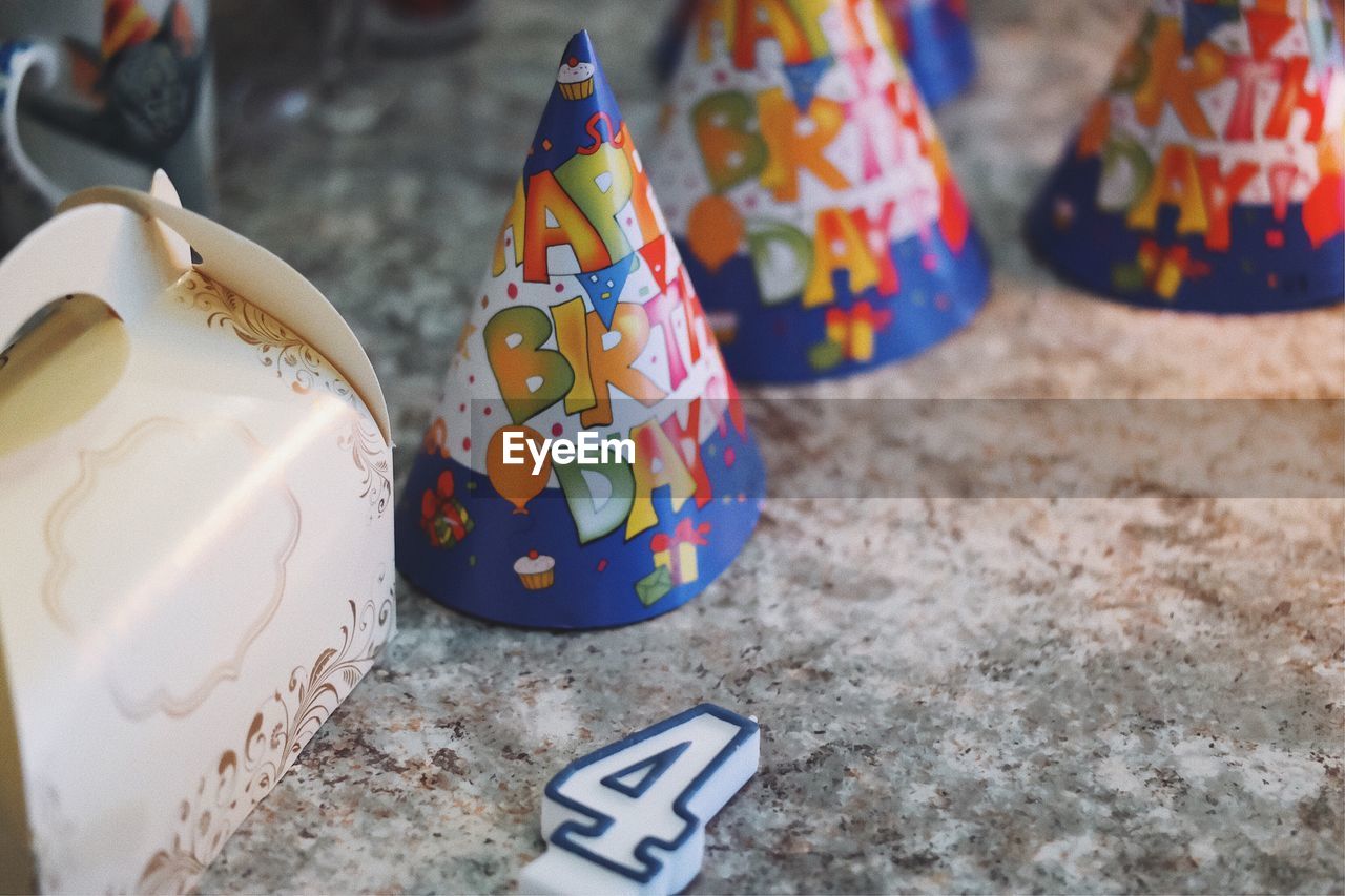Party hats with birthday candle on table
