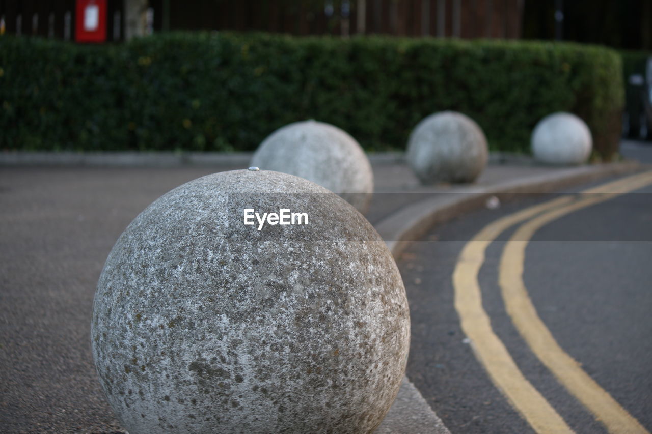 Spherical stones in row on sidewalk