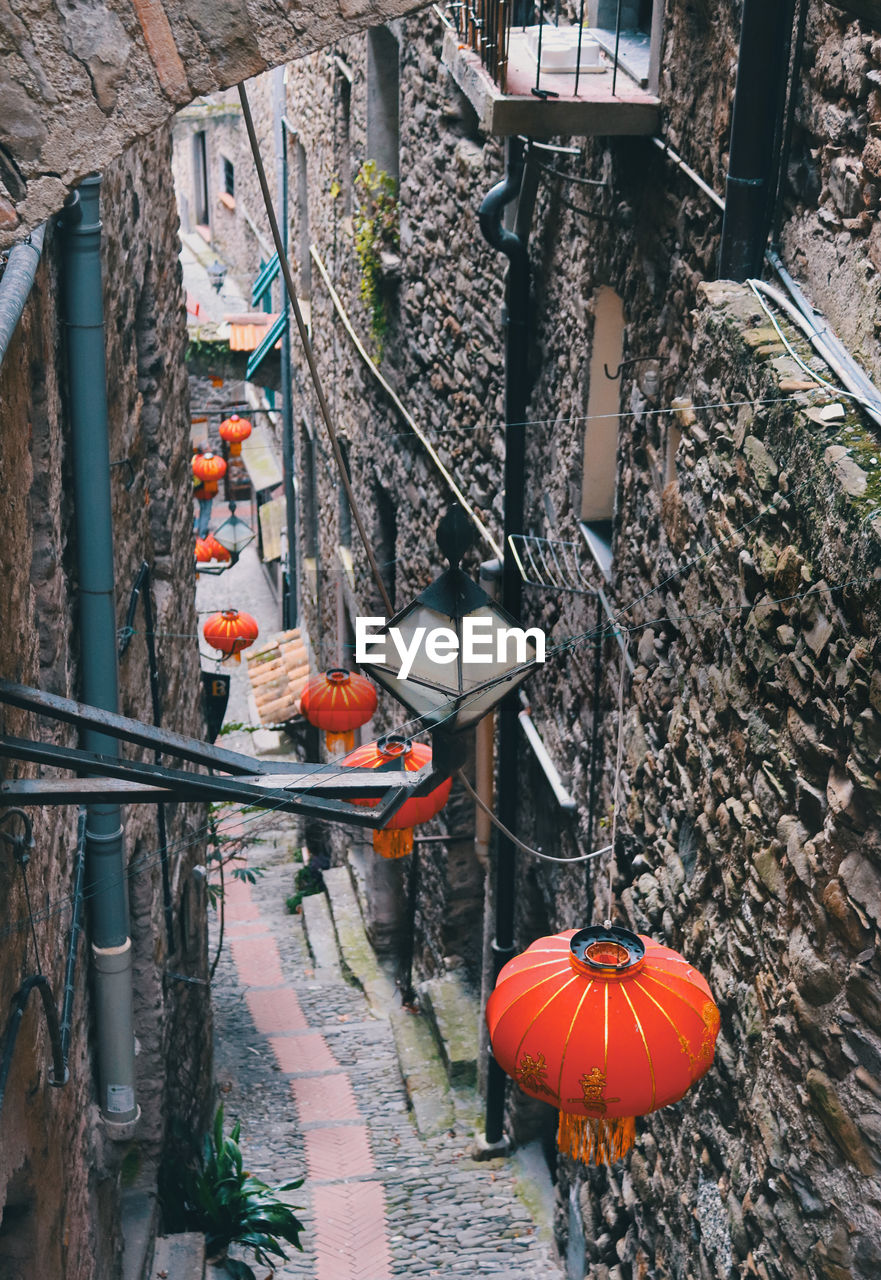 HIGH ANGLE VIEW OF LANTERN HANGING ON FOOTPATH BY BUILDINGS