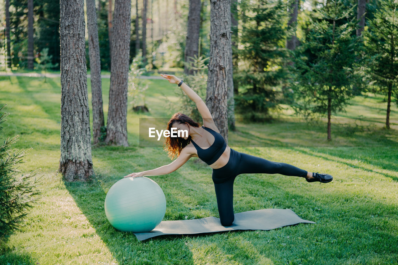 High angle view of woman with fitness ball exercising in park