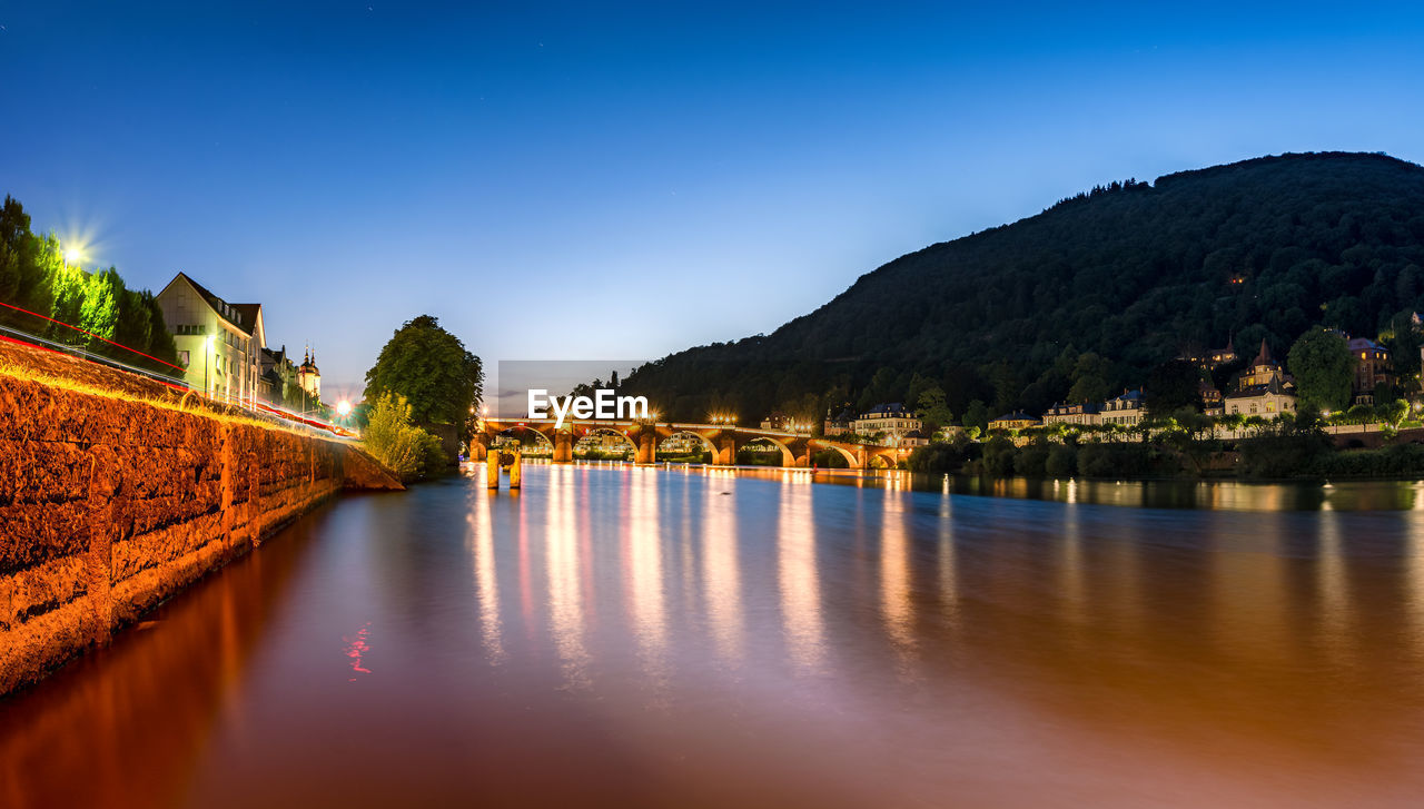 SCENIC VIEW OF LAKE BY BUILDINGS AGAINST CLEAR BLUE SKY