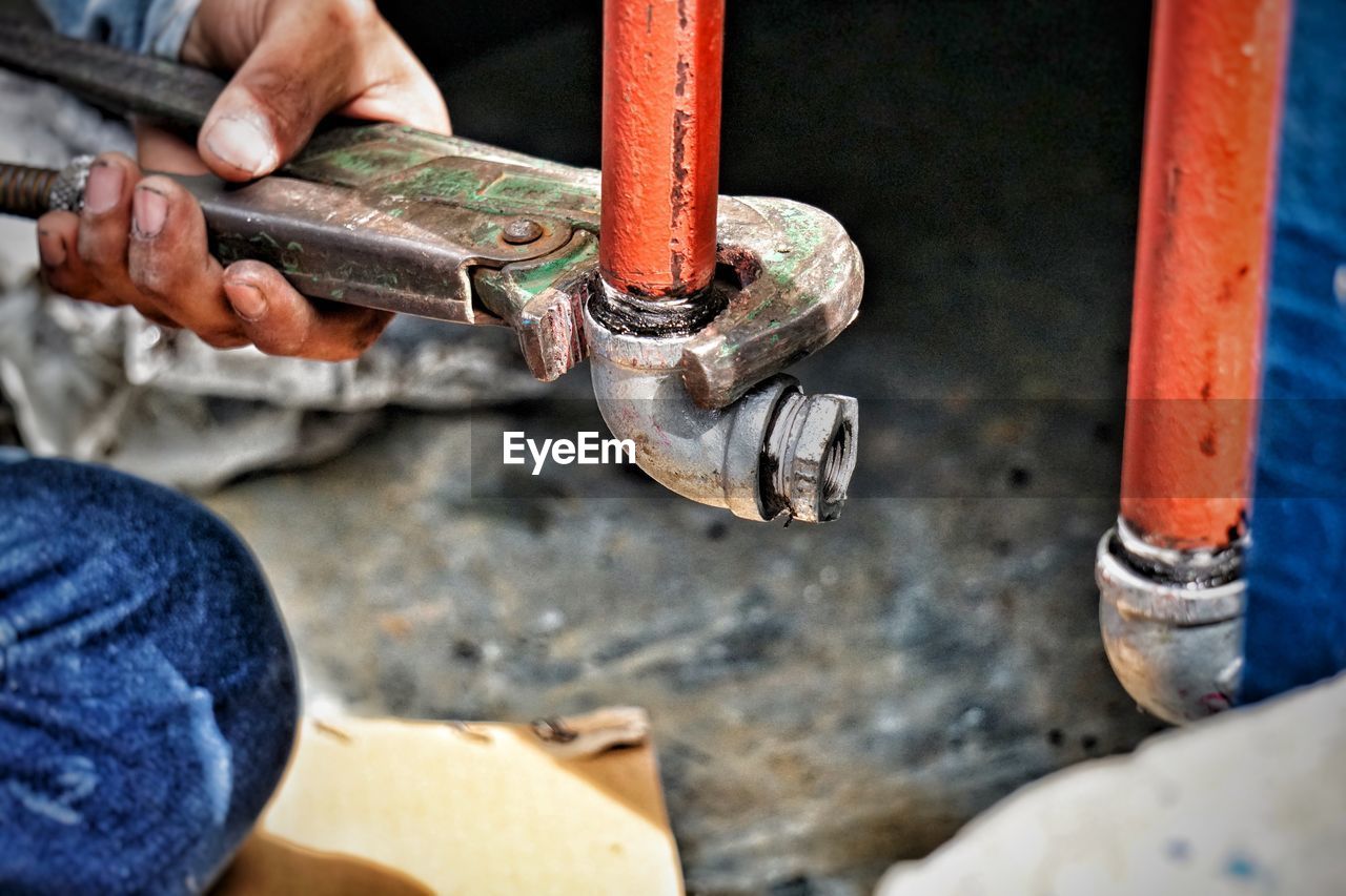 Close-up of plumber repairing pipe