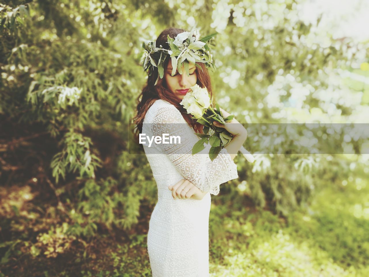 Side view of young woman holding flowers