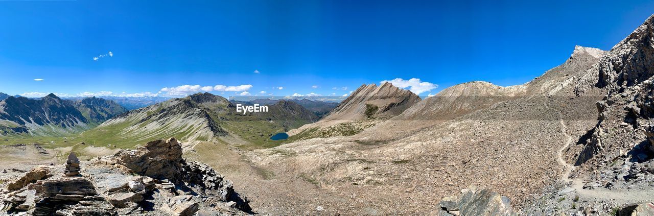 Panoramic view of rocky mountains against blue sky