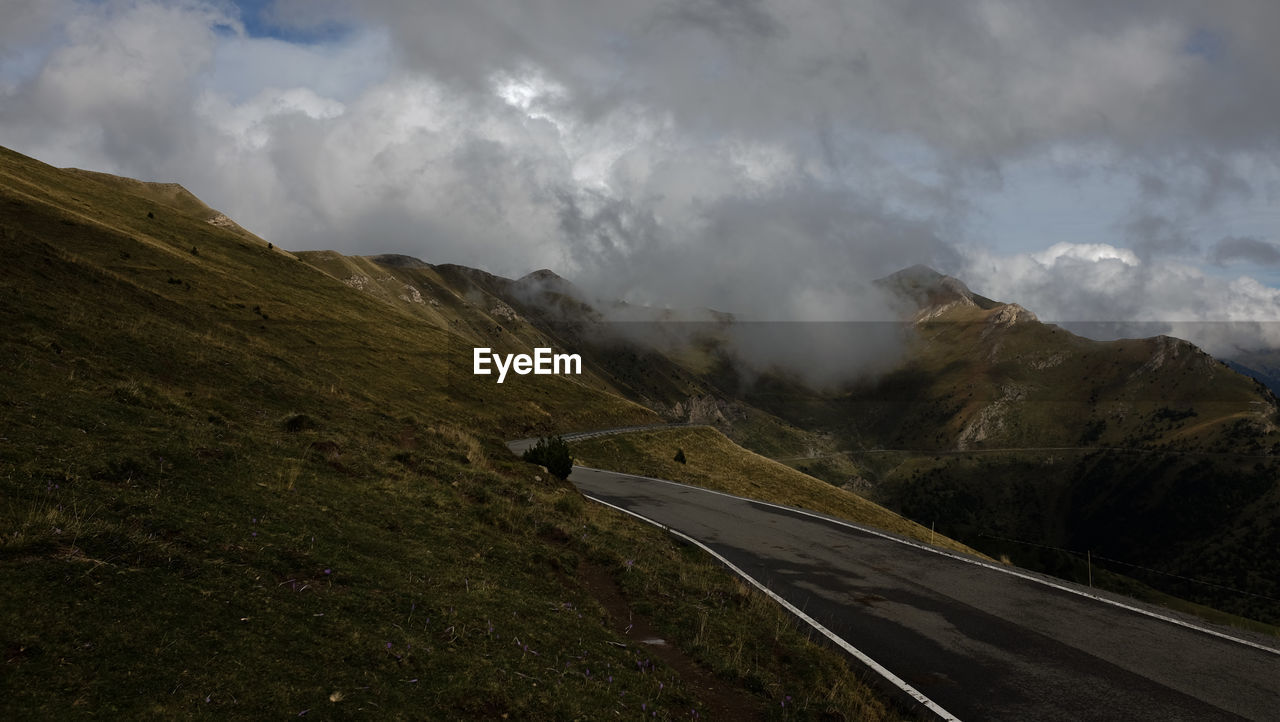 Scenic view of road amidst mountains against sky