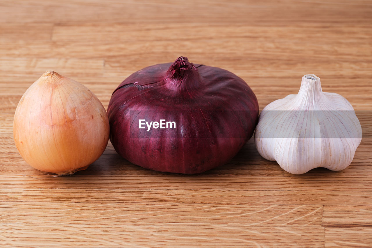 CLOSE-UP OF PUMPKINS ON WOODEN TABLE