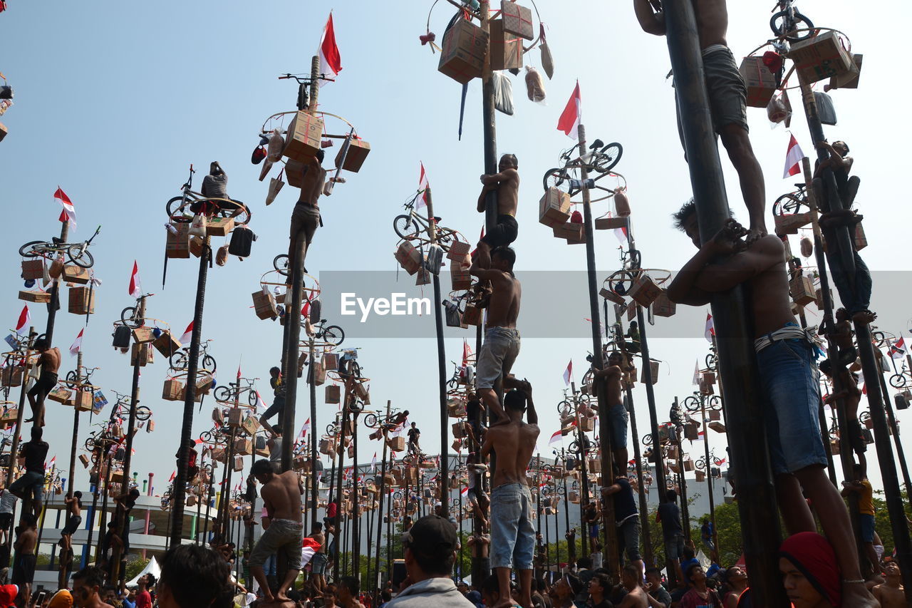 LOW ANGLE VIEW OF CROWD AGAINST SKY