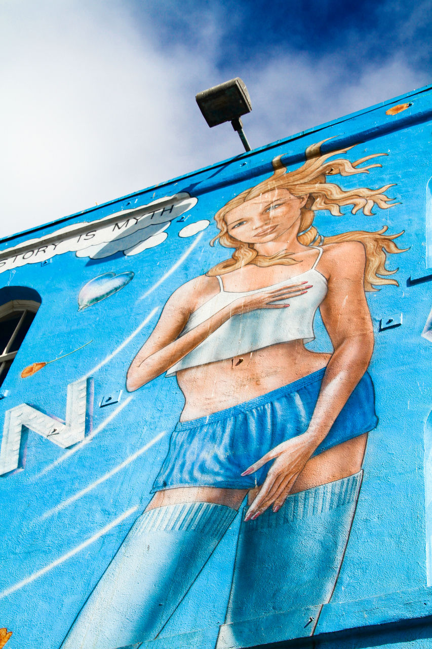 CLOSE-UP LOW ANGLE VIEW OF WOMAN AGAINST SKY