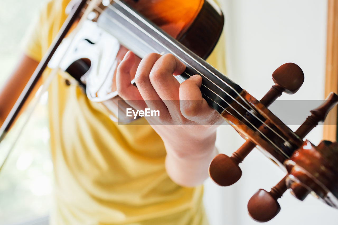 Midsection of boy playing guitar