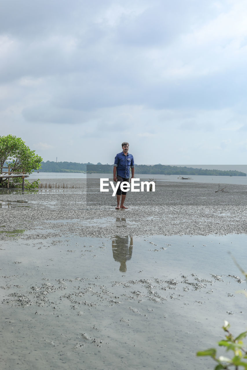 water, sky, beach, full length, land, shore, one person, nature, cloud, body of water, sea, day, leisure activity, men, sand, coast, casual clothing, lifestyles, adult, beauty in nature, standing, ocean, front view, vacation, holiday, walking, outdoors, mature adult, scenics - nature, trip, plant, person, tranquility