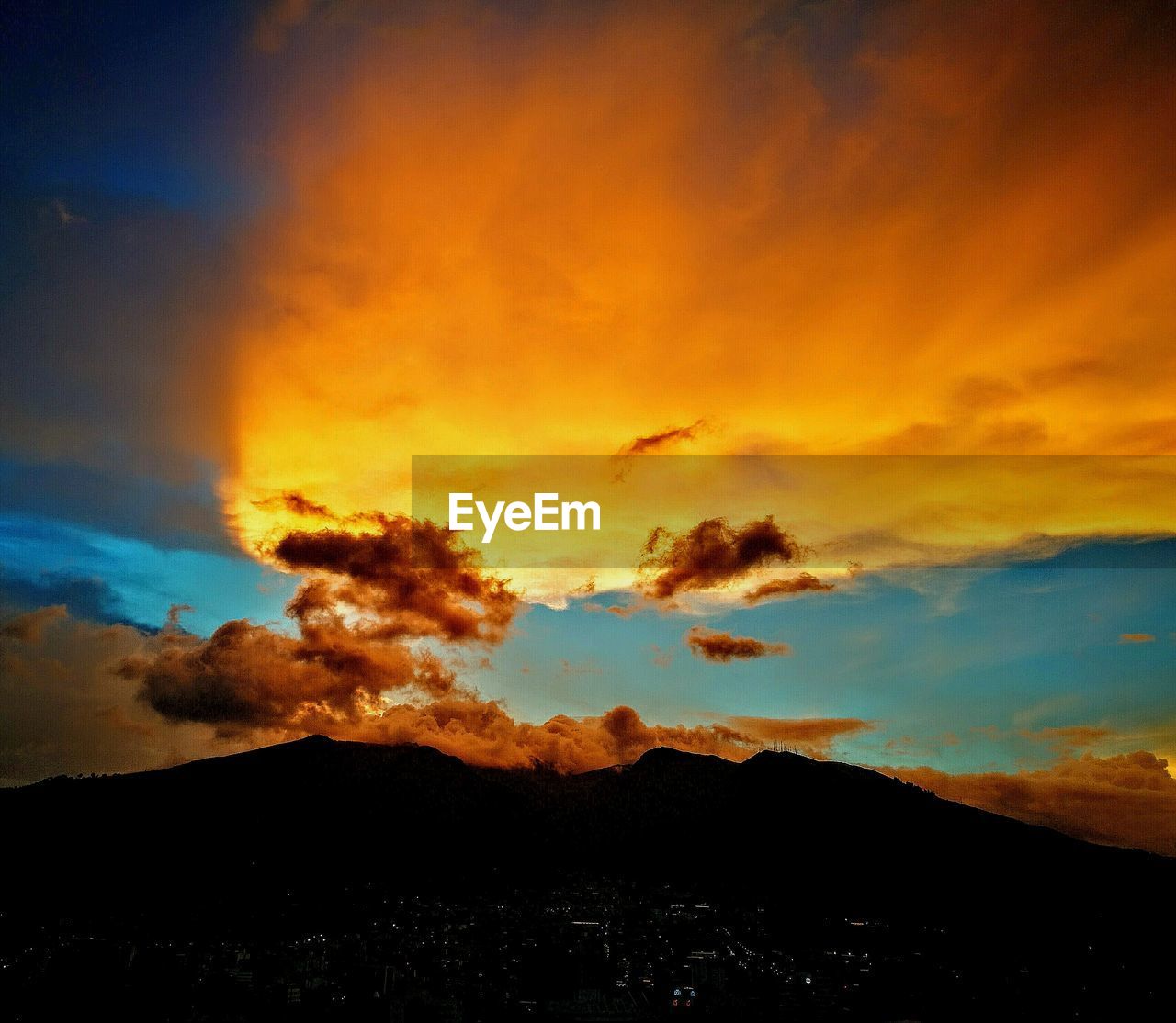 SCENIC VIEW OF SILHOUETTE MOUNTAIN AGAINST DRAMATIC SKY DURING SUNSET