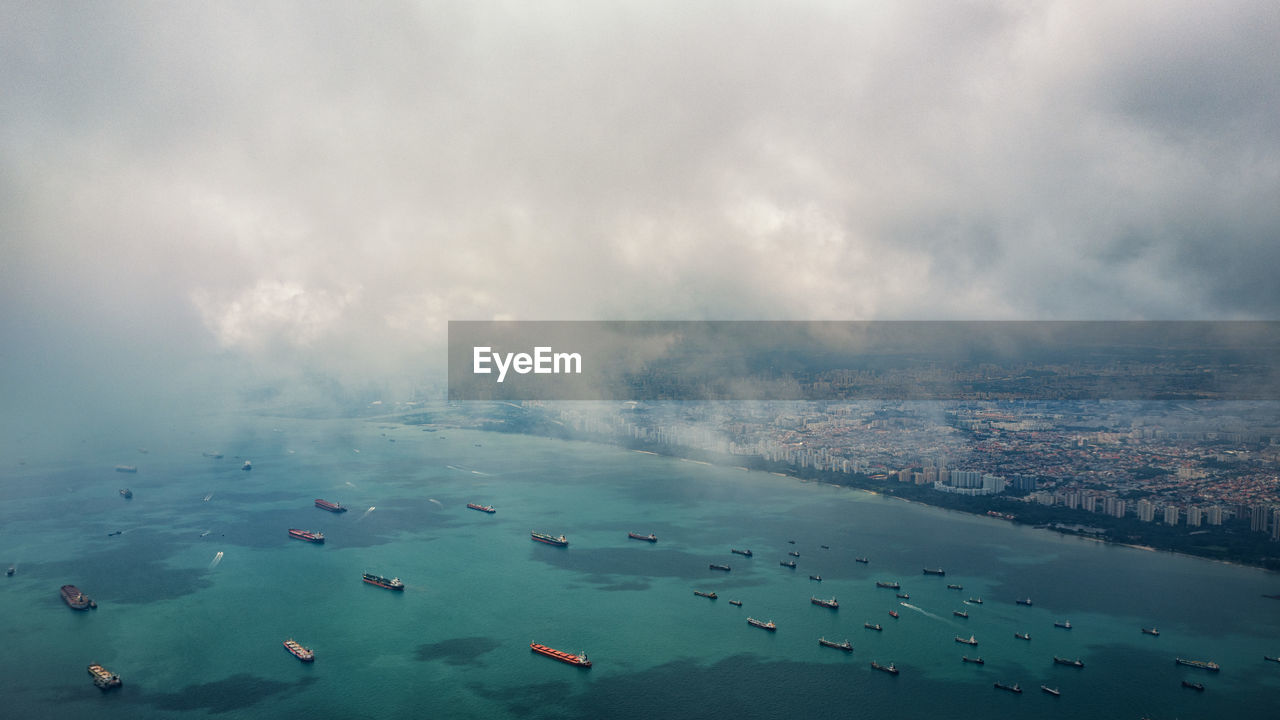 Aerial view of boats in sea against cloudy sky