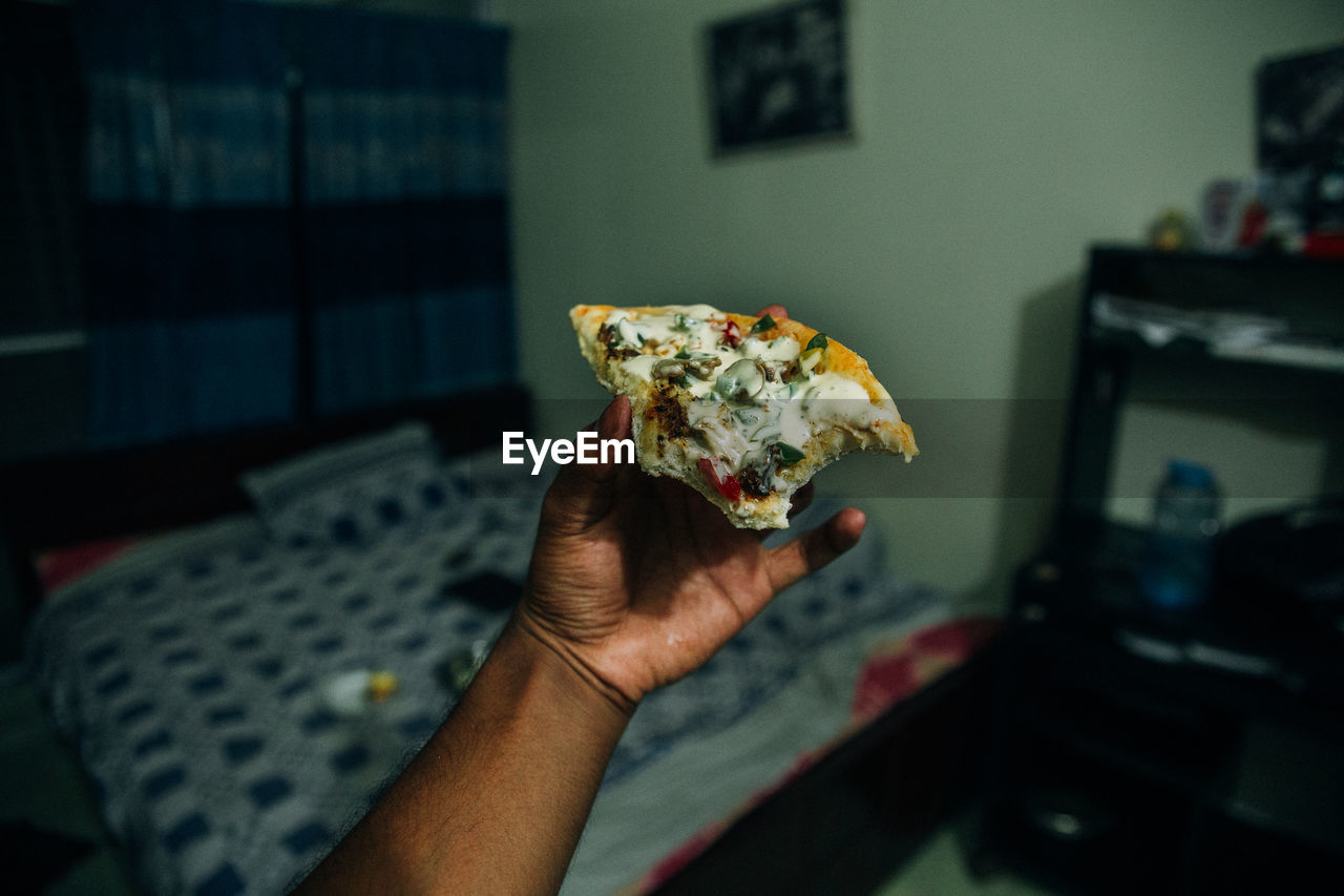 A bitten pizza on a hand 