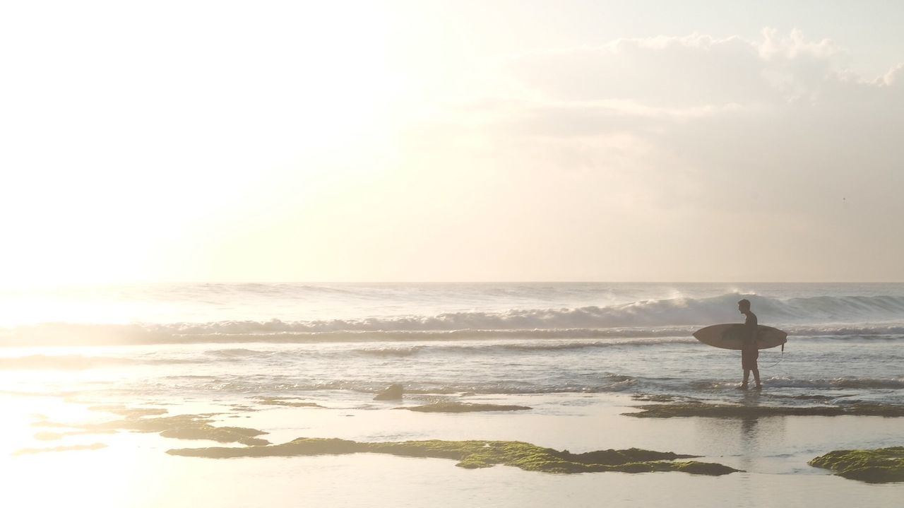 Man with surfboard on shore