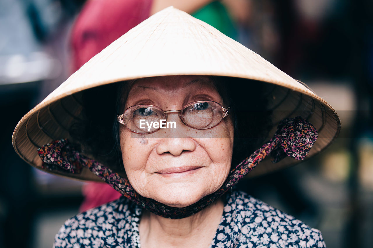 CLOSE-UP PORTRAIT OF WOMAN WITH HAT IN PARK