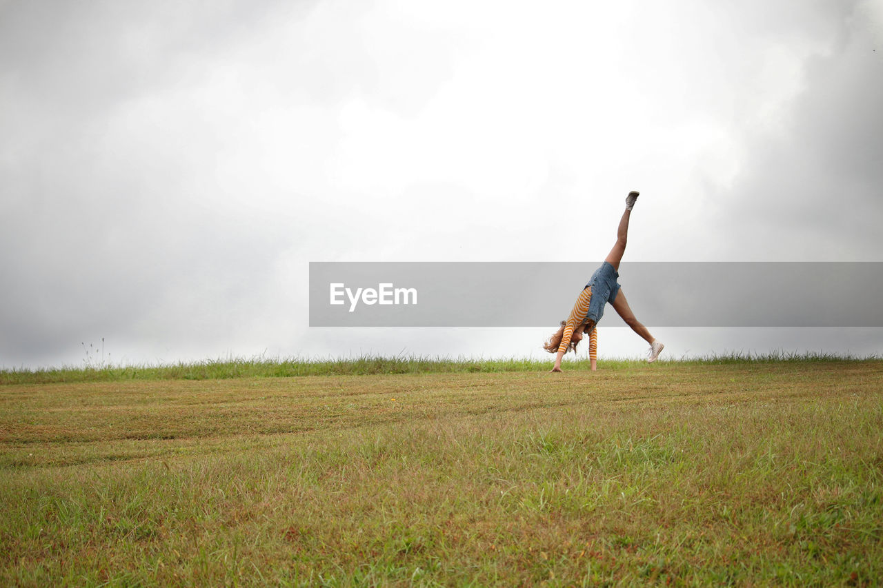 MAN IN FIELD AGAINST SKY