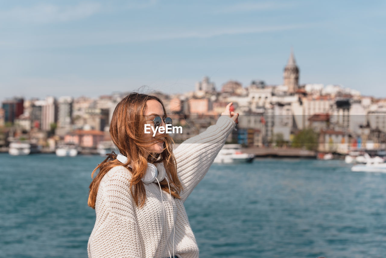 WOMAN LOOKING AT CITYSCAPE WITH CANAL