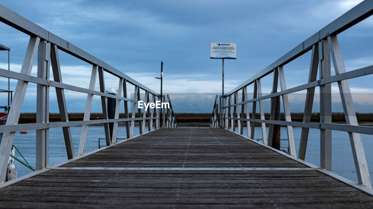 Empty footbridge against sky