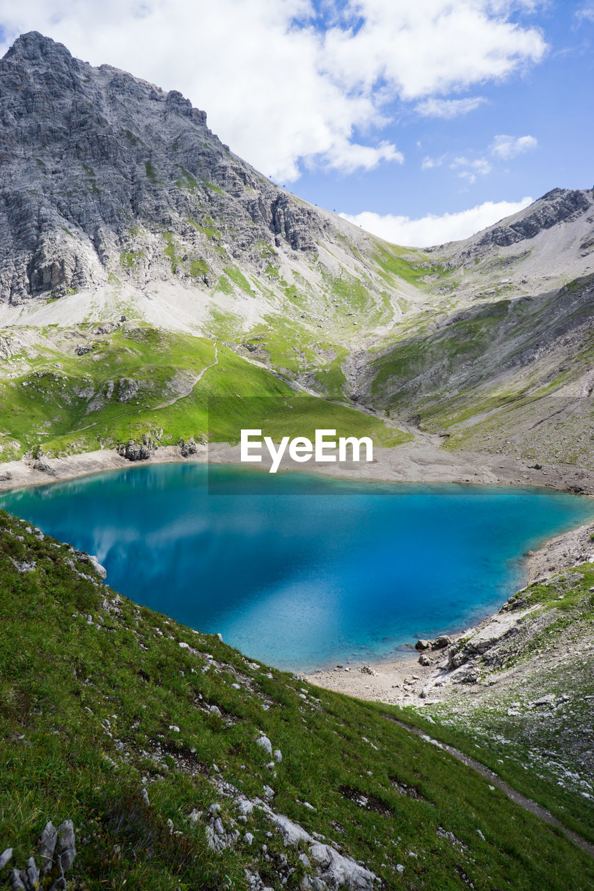 Scenic view of lake by mountains against sky