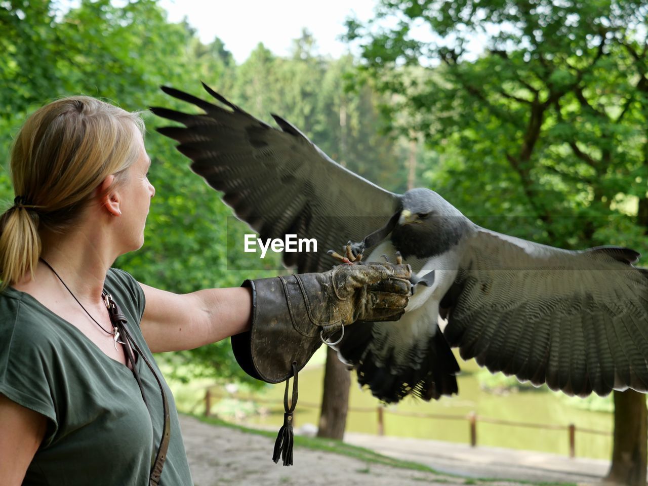 Side view of woman with birds in zoo