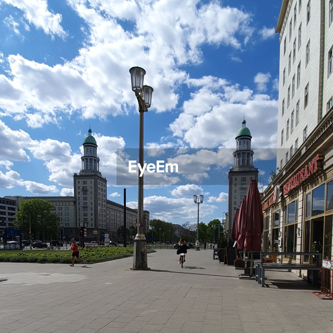 PEOPLE ON STREET BY BUILDINGS AGAINST SKY