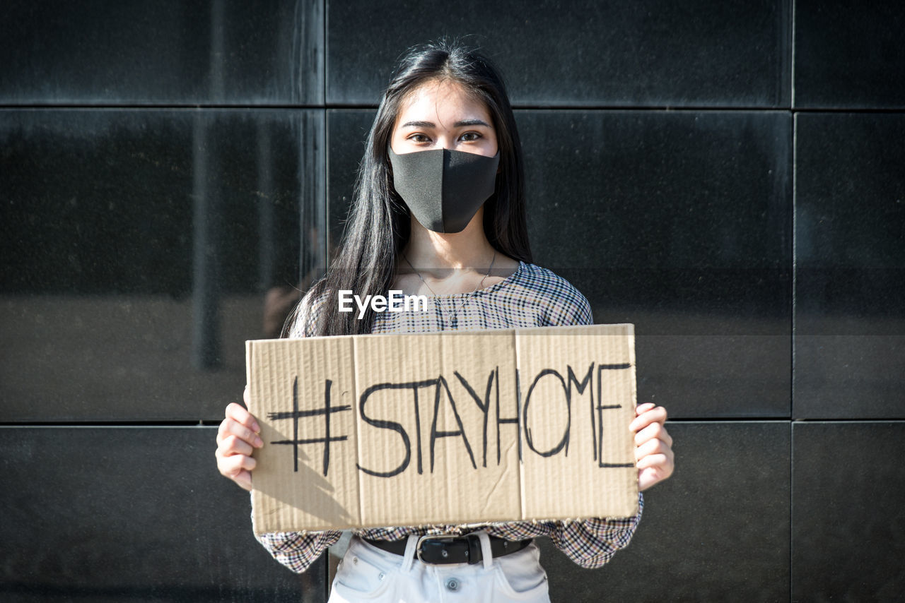 Portrait of woman holding paper with text