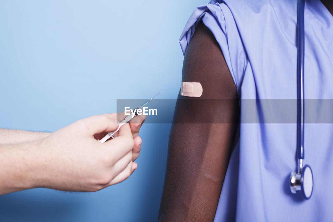 cropped hand of doctor holding thermometer