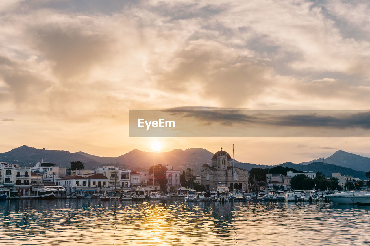 SAILBOATS IN CITY DURING SUNSET