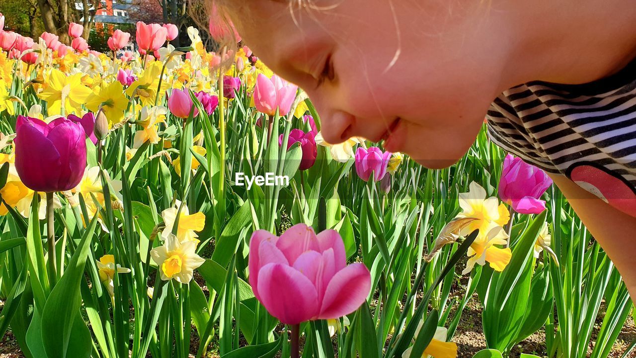 CLOSE-UP OF GIRL WITH PINK FLOWERS