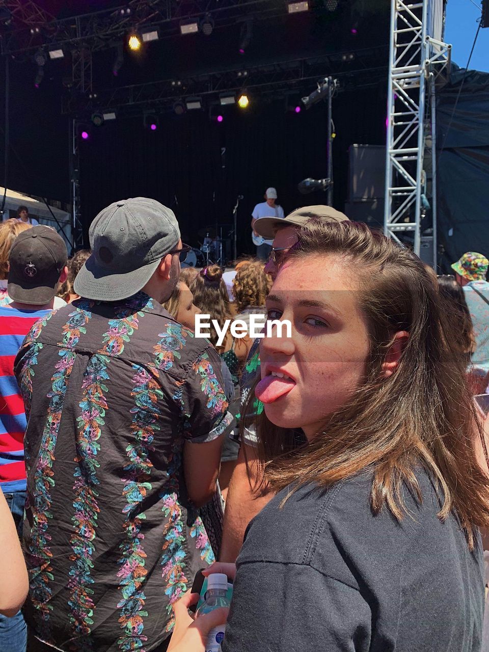 Portrait of woman sticking out tongue during concert